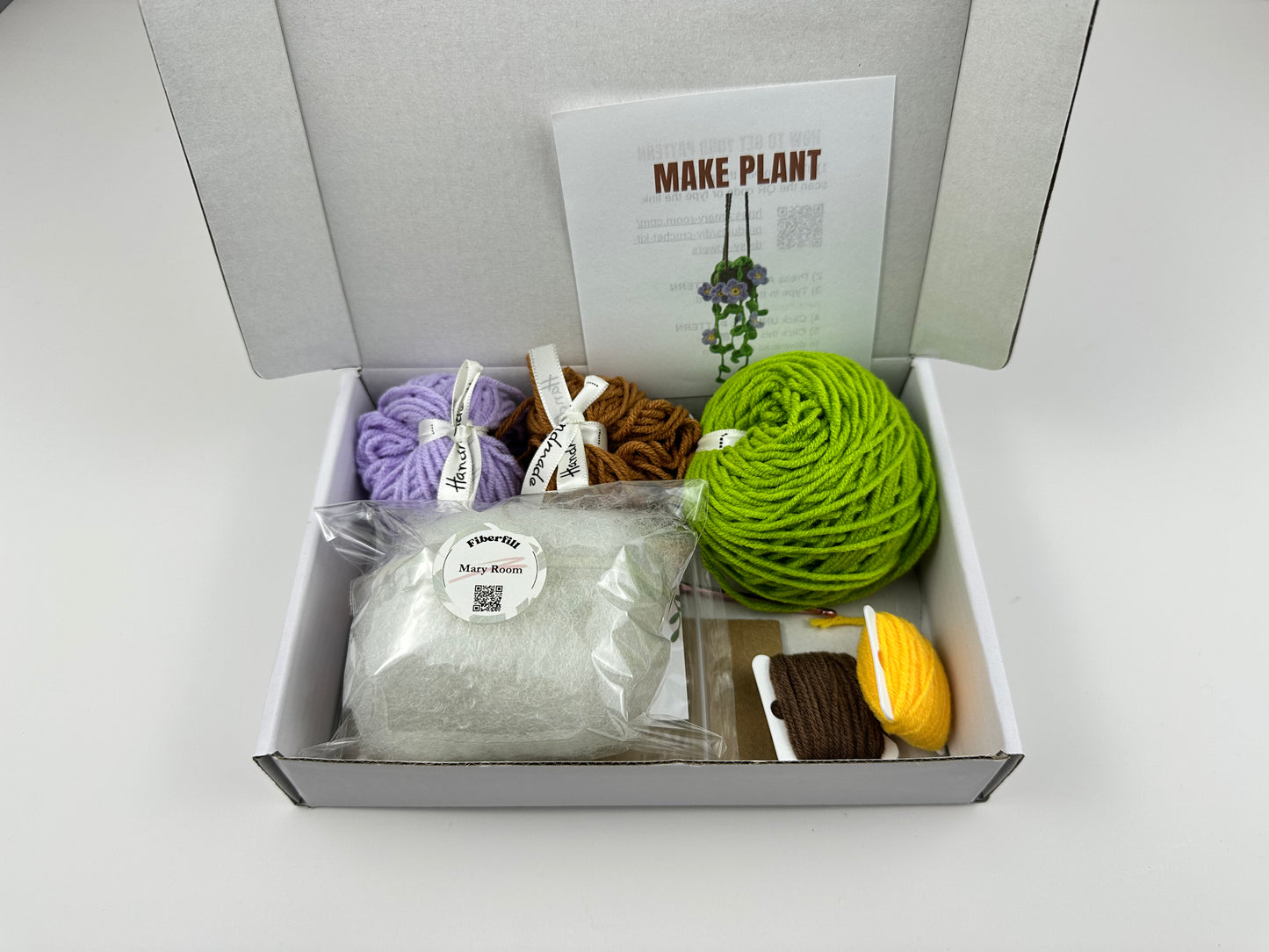 Decorative crochet plant with purple daisies hanging from pot, DIY craft kit