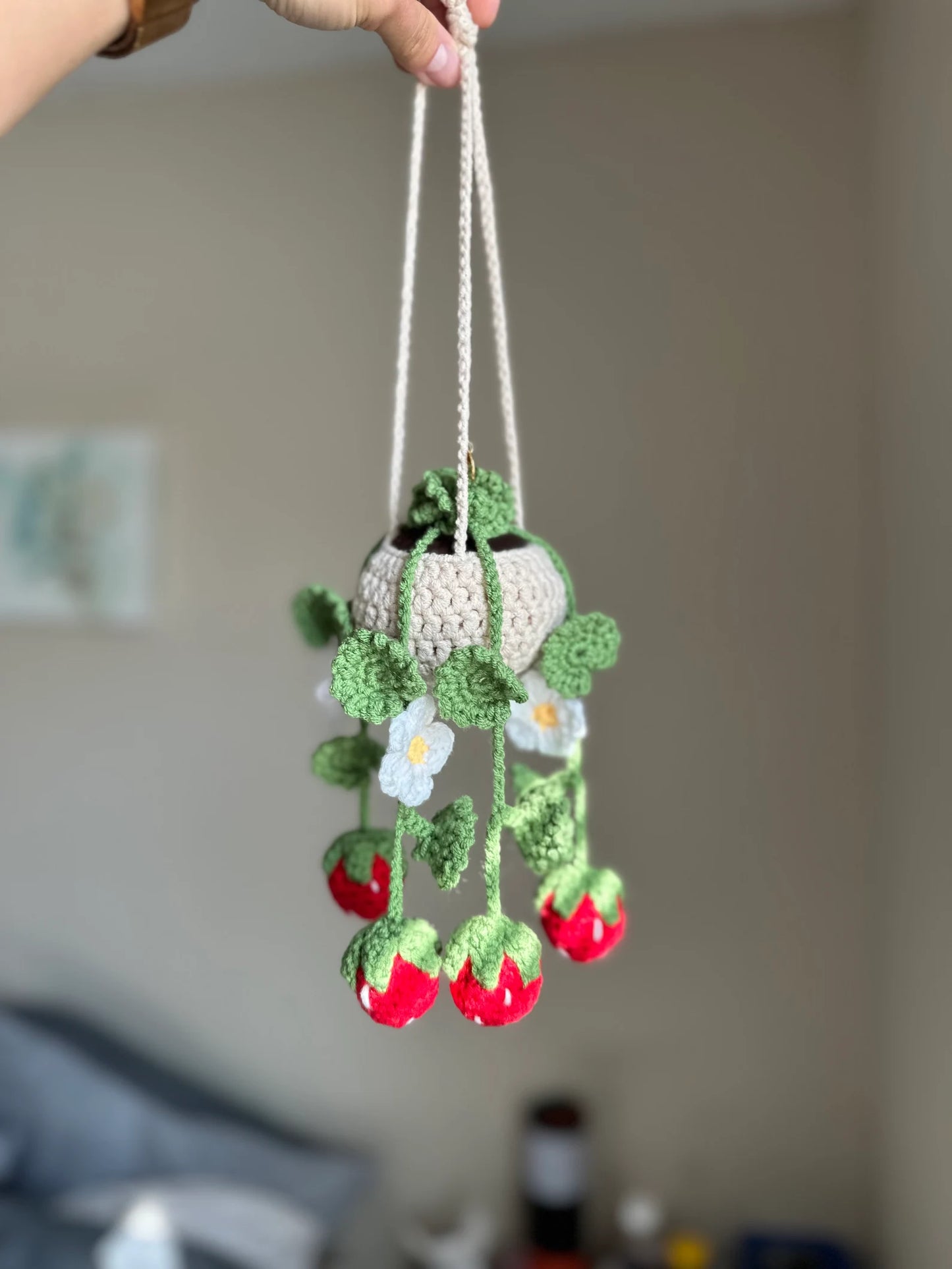 Close-up of crochet stitch detail showing white flower petals and green leaf texture on vine