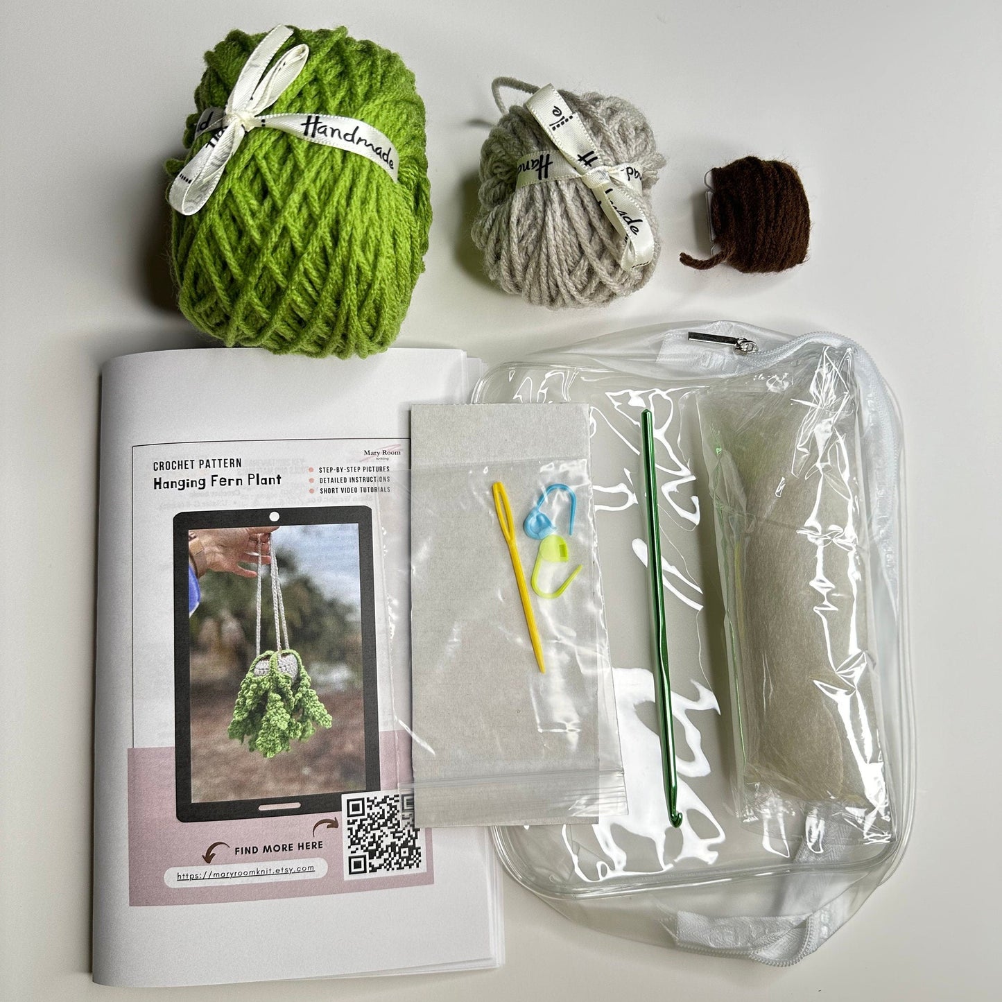 Kit contents — green yarn, stuffing, crochet hook, and printed pattern