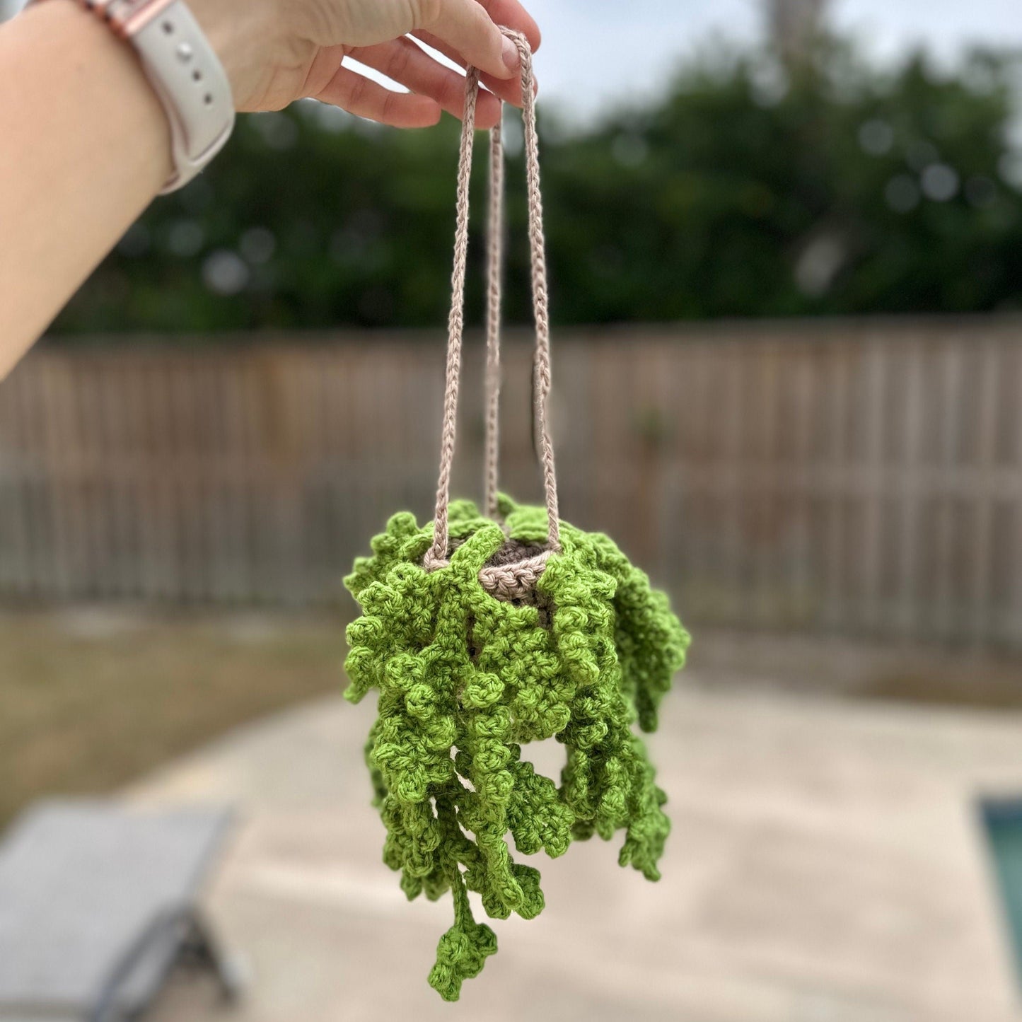 Hand holding complete crochet kit in clear bag