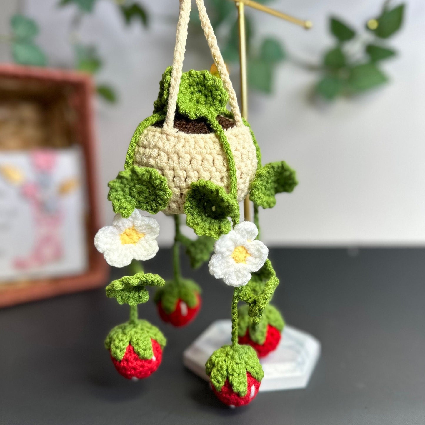 Handmade crochet strawberry plant hanging as boho wall decor with natural background