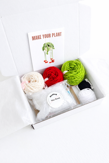 Open gift box with yarn and pattern card for DIY Crochet Kit Red Bells Plant – ready for gifting.