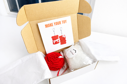 Open crochet kit box showing red yarn, tools, and printed materials inside – DIY Crochet Kit for Valentine’s Day (Kissing Bears)