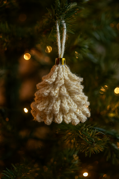 Cream crochet Christmas ornament with metallic gold thread hanging on a decorated tree