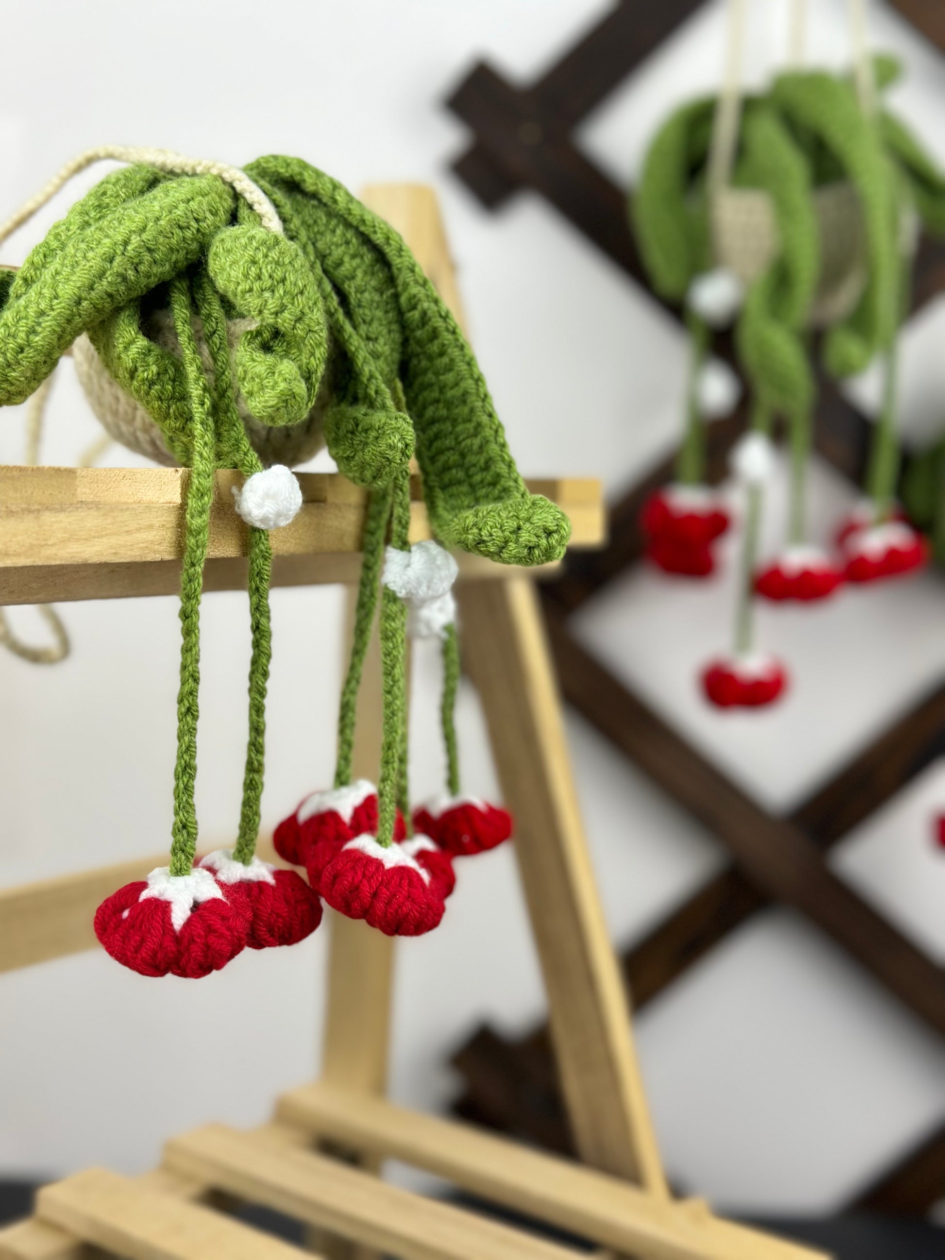 Close-up of crochet red bells plant pattern showing leaf and flower details