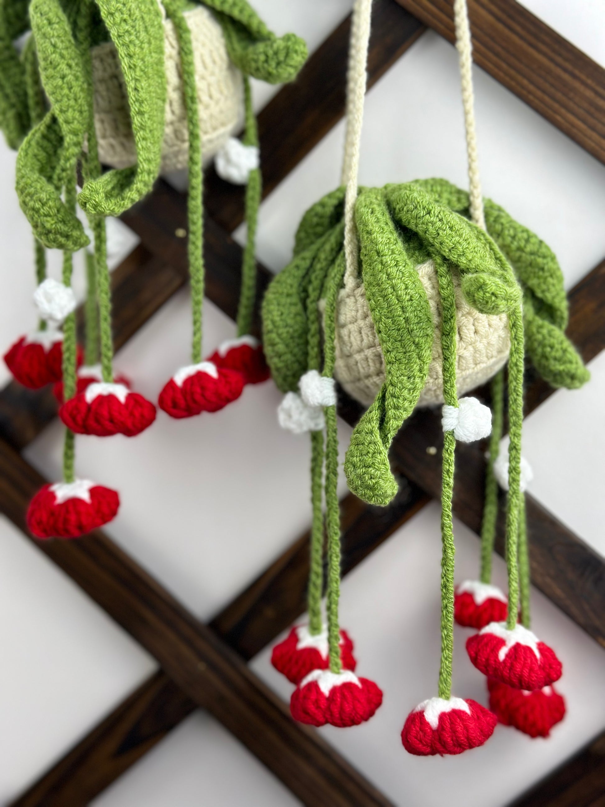 Detailed crochet red bells flower pattern with textured leaves and hanging stems”
