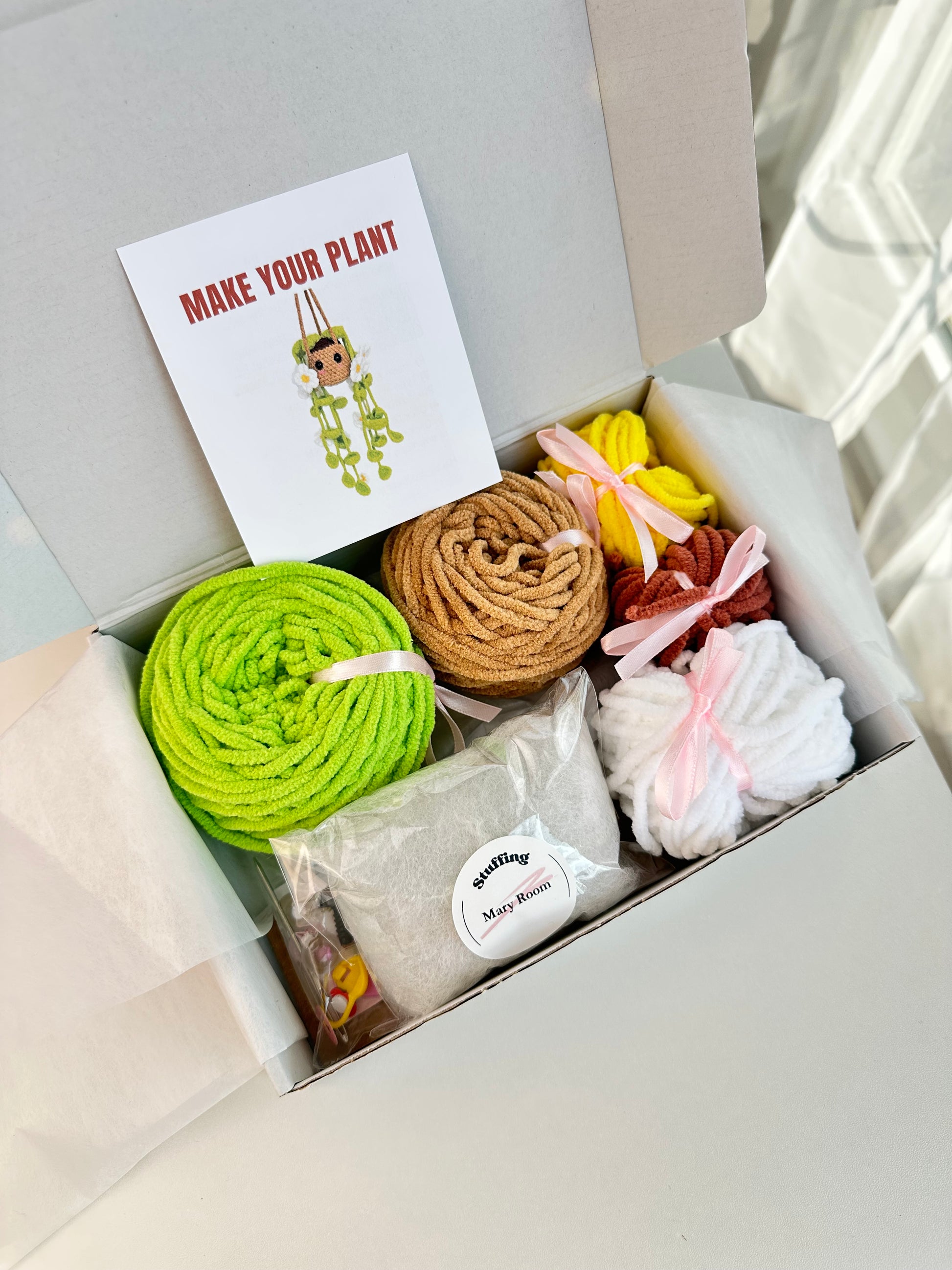 Unboxing the Crochet KIT Plush Plant with Daisy Flowers — colorful yarn and all supplies neatly arranged.