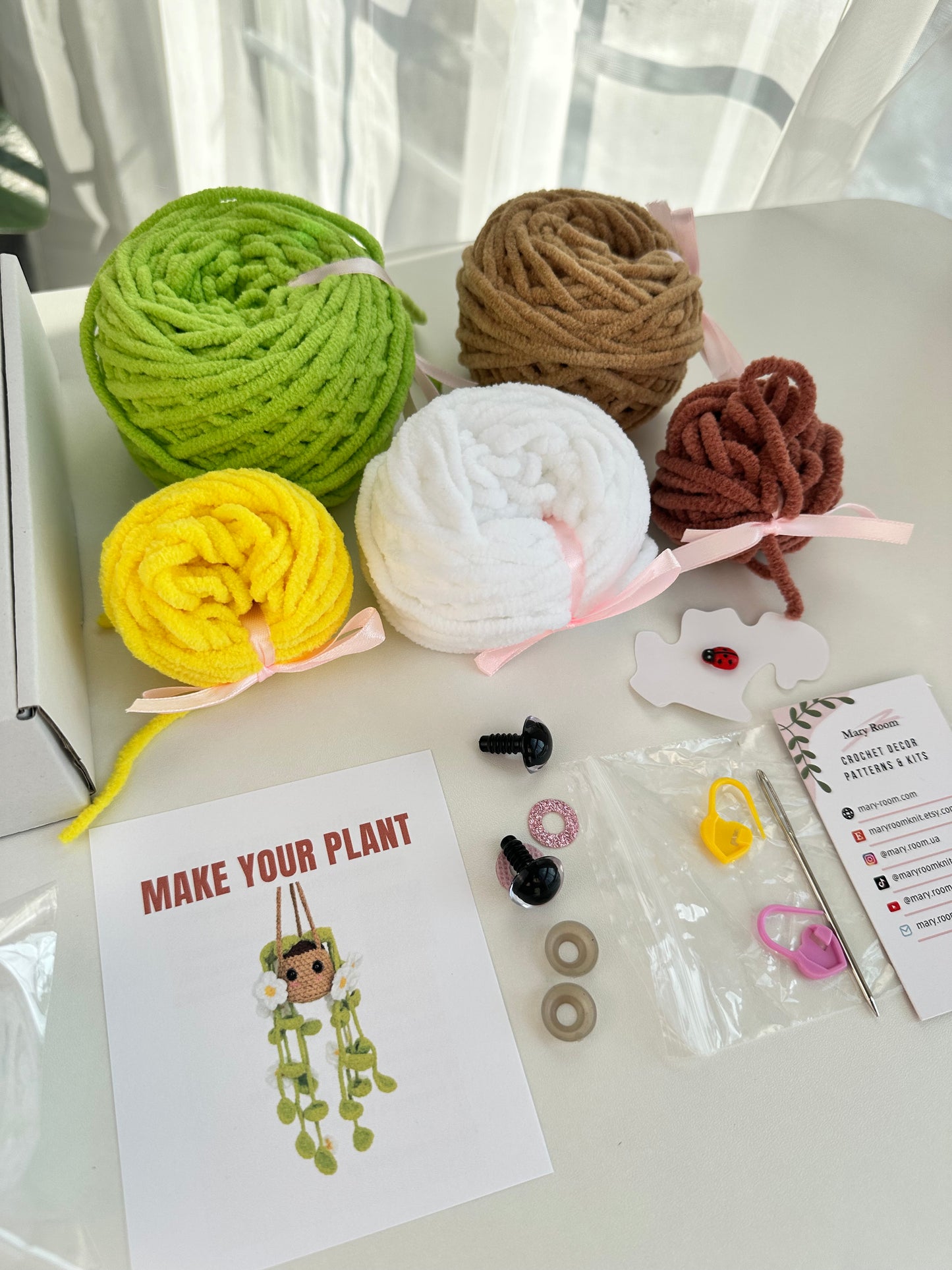 All components of the Crochet KIT Plush Plant with Daisy Flowers shown on a table, ready for use.