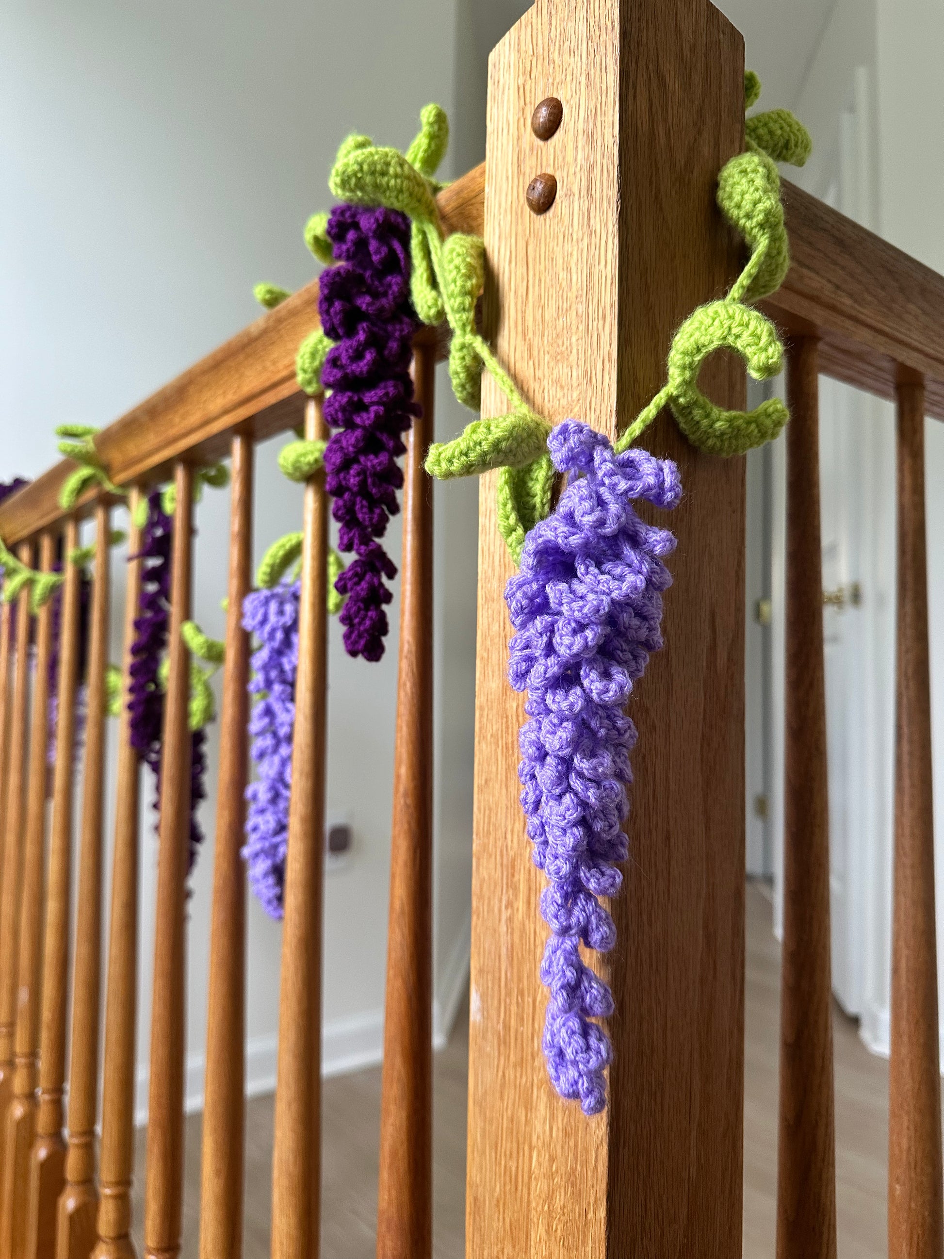 Multiple crochet wisteria plants in different sizes hanging together for display