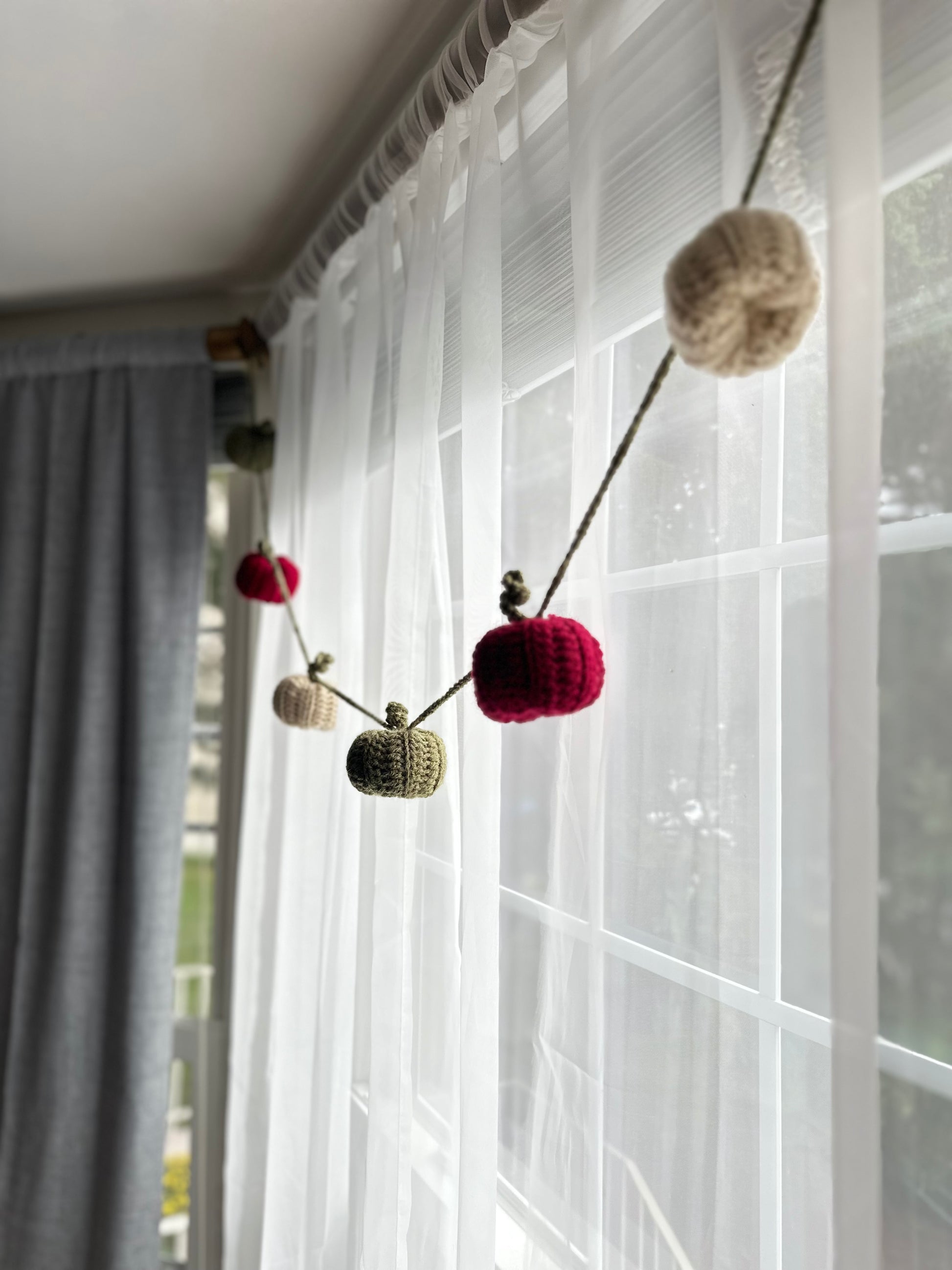 Decorative garland with pumpkins hanging on a sheer curtain