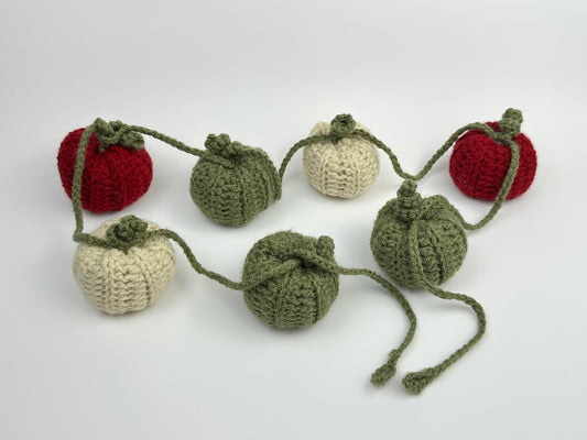 Crocheted pumpkin garland on a white background