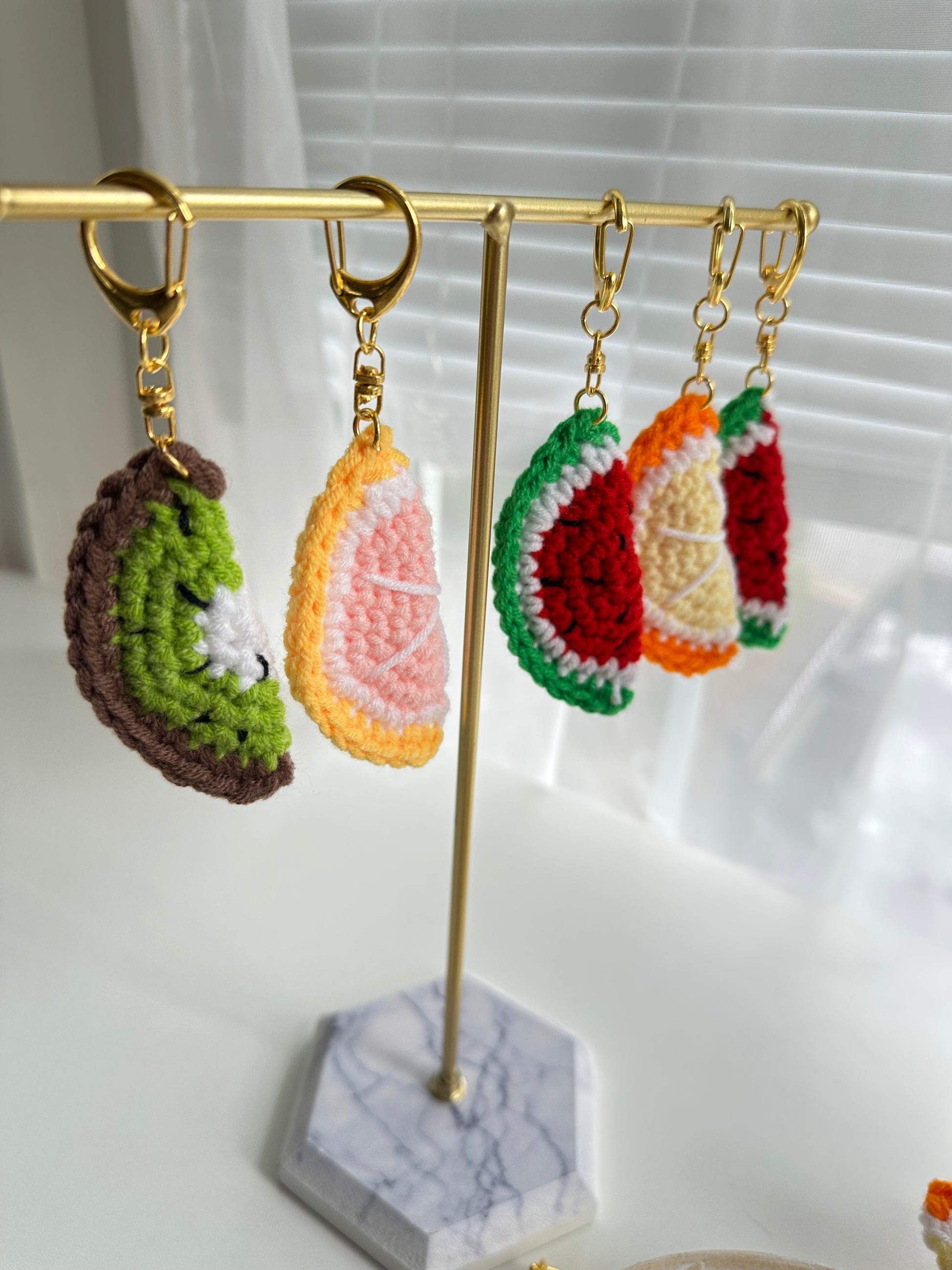 Soft handmade crochet fruit accessories with colorful yarn details

