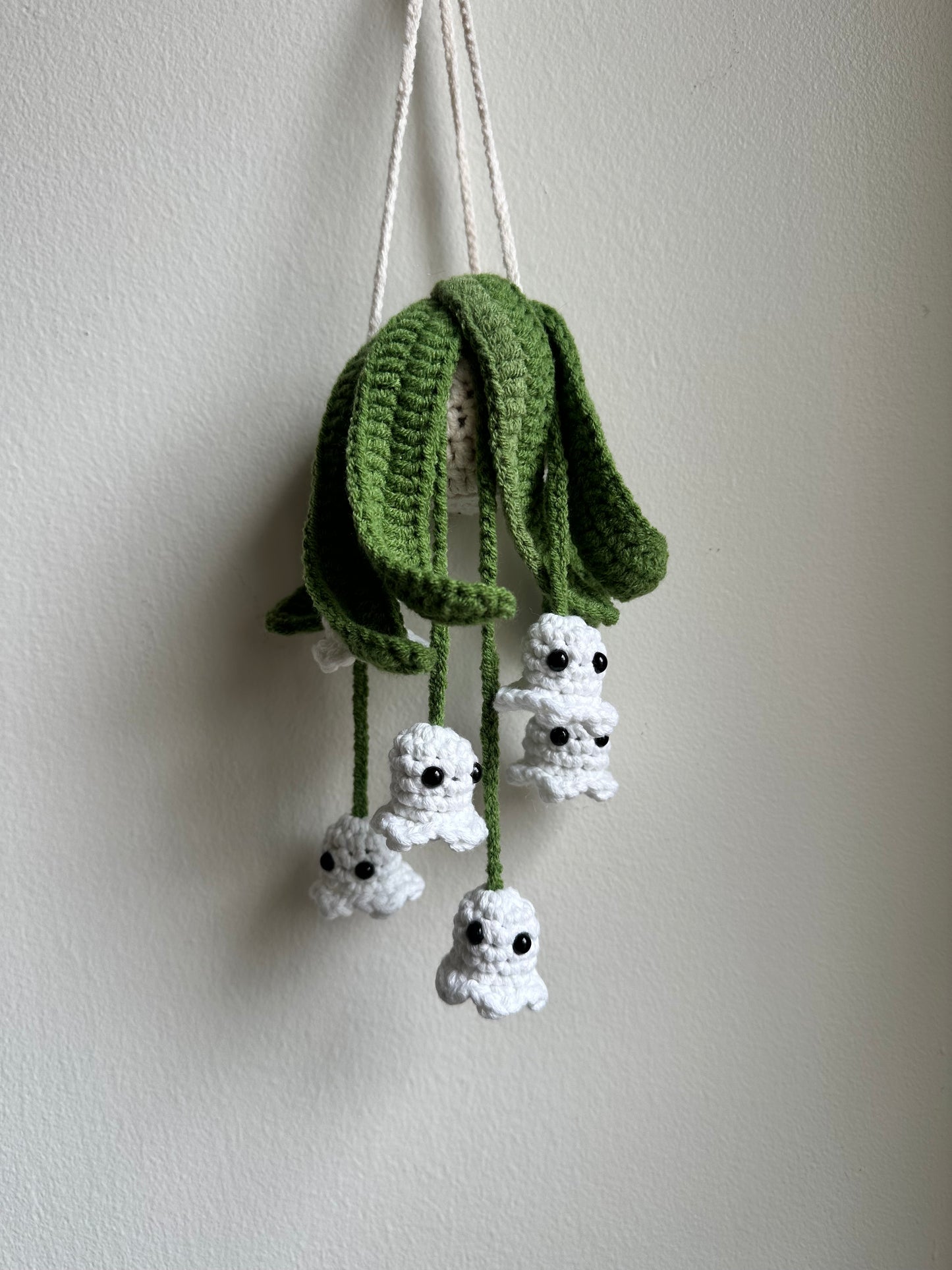Crochet hanging ghost plant pattern with white glow-in-the-dark yarn, perfect Halloween crochet decor.