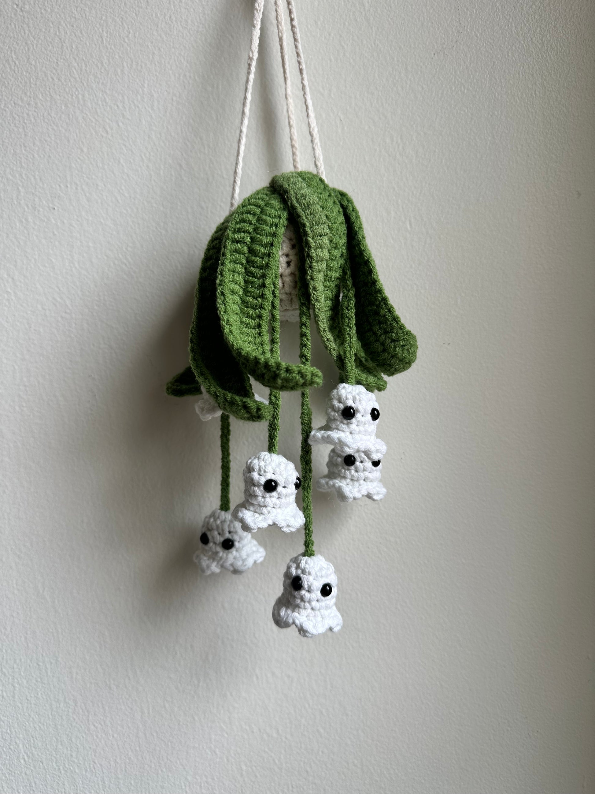 Crochet hanging ghost plant pattern with white glow-in-the-dark yarn, perfect Halloween crochet decor.