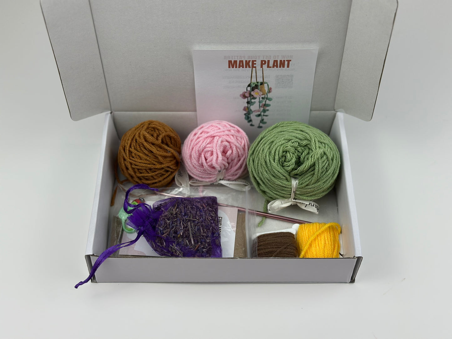 Box containing yarn balls and crochet hook, markers, sachet of lavender and a 'Make Plant' instruction sheet.