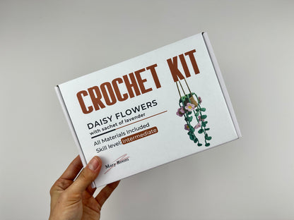 Crochet kit hanging daisy flowers plant packaging with floral design and text on a gray background