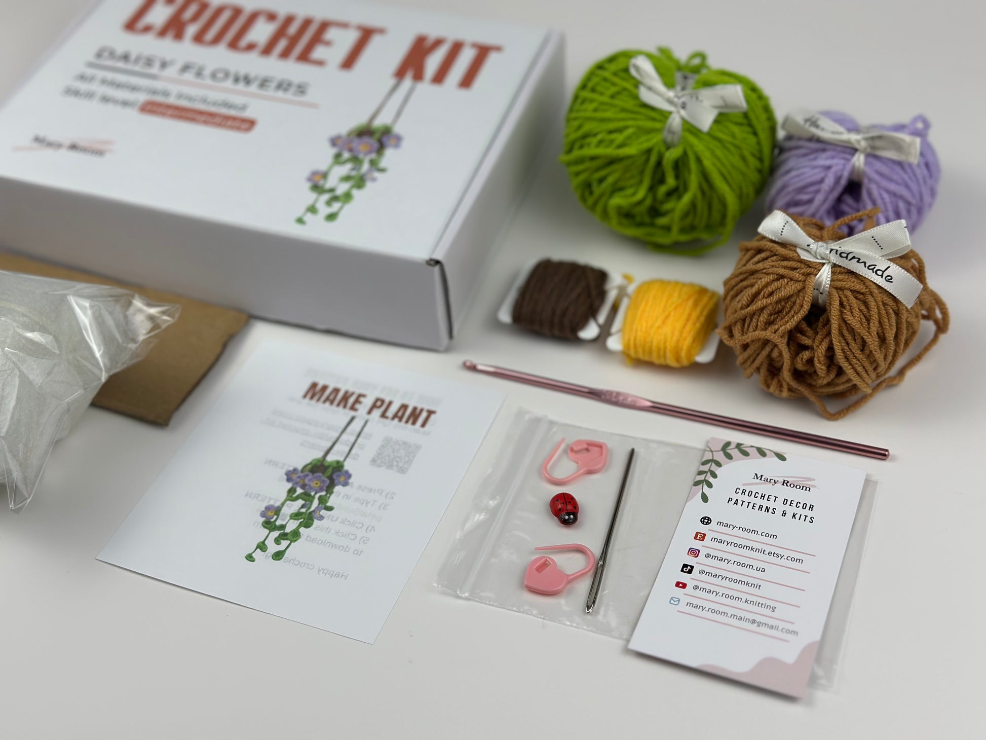 Crochet kit with yarn balls, a crochet hook, and instructions on a white surface