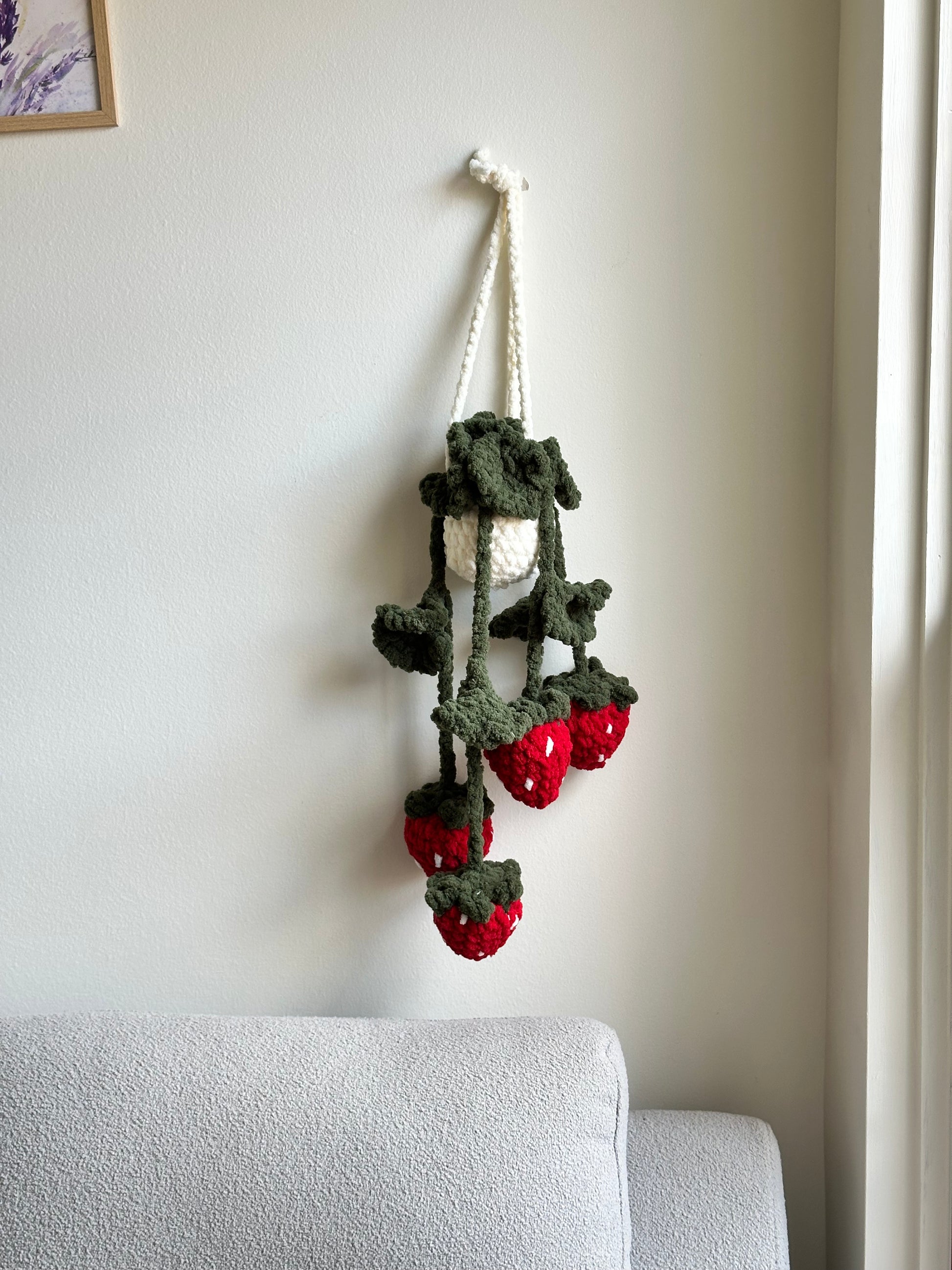 Crochet plush hanging plant with strawberries and green leaves