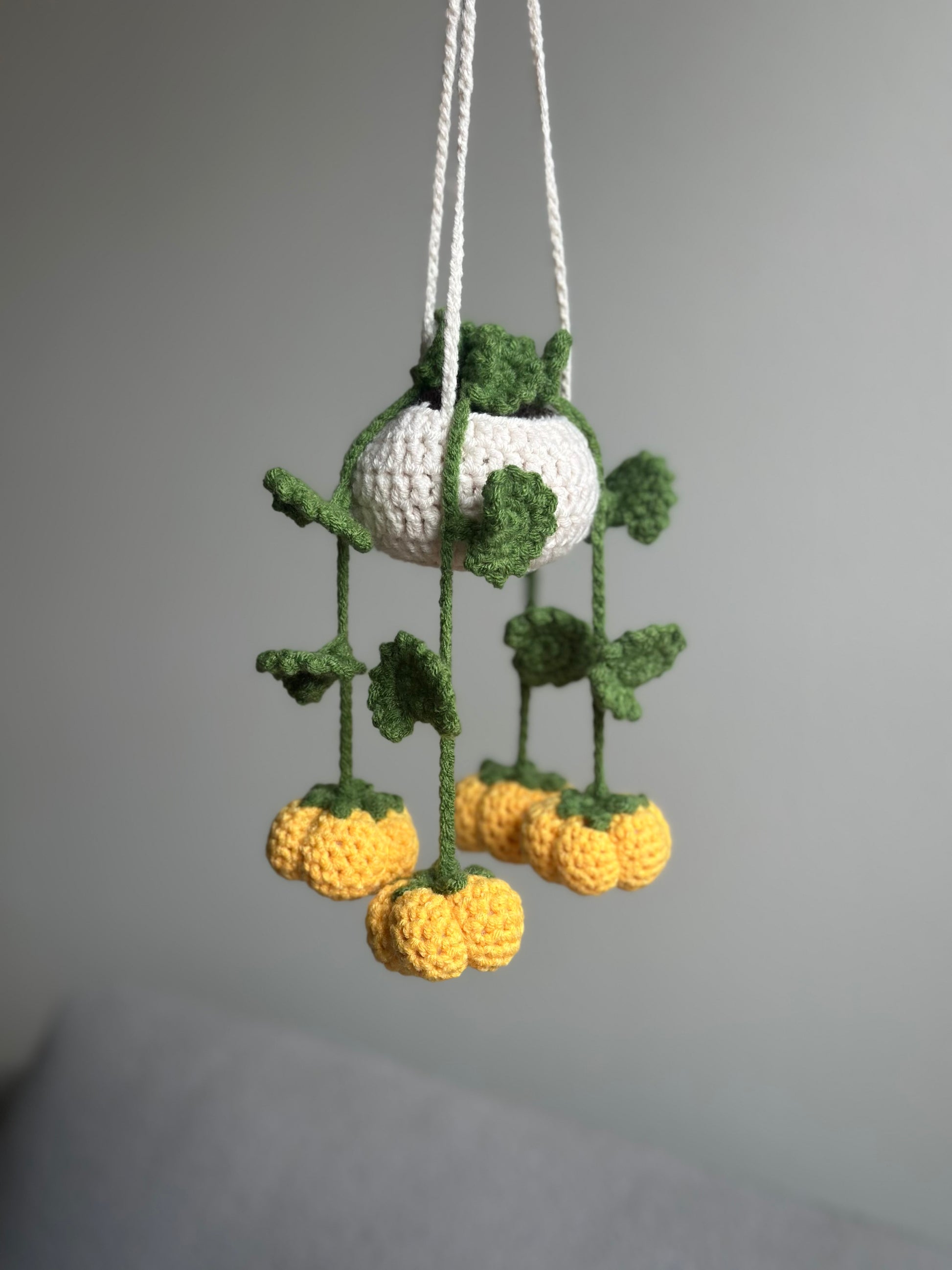 Crochet pumpkin hanging plant pattern — handmade Halloween amigurumi plant decoration.