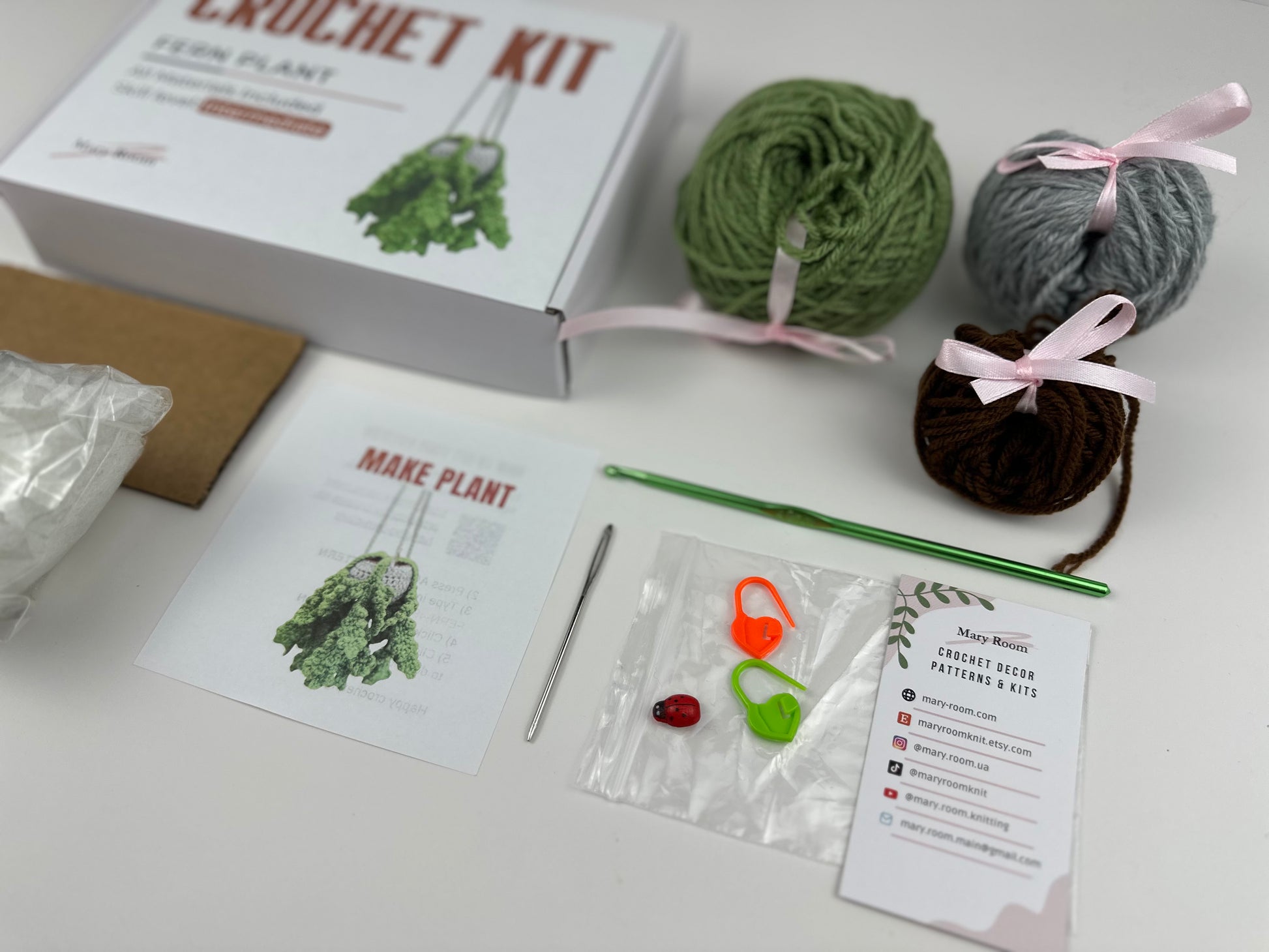 Crochet plant kit packaging with yarn, pattern, and tools for creating a hanging fern.