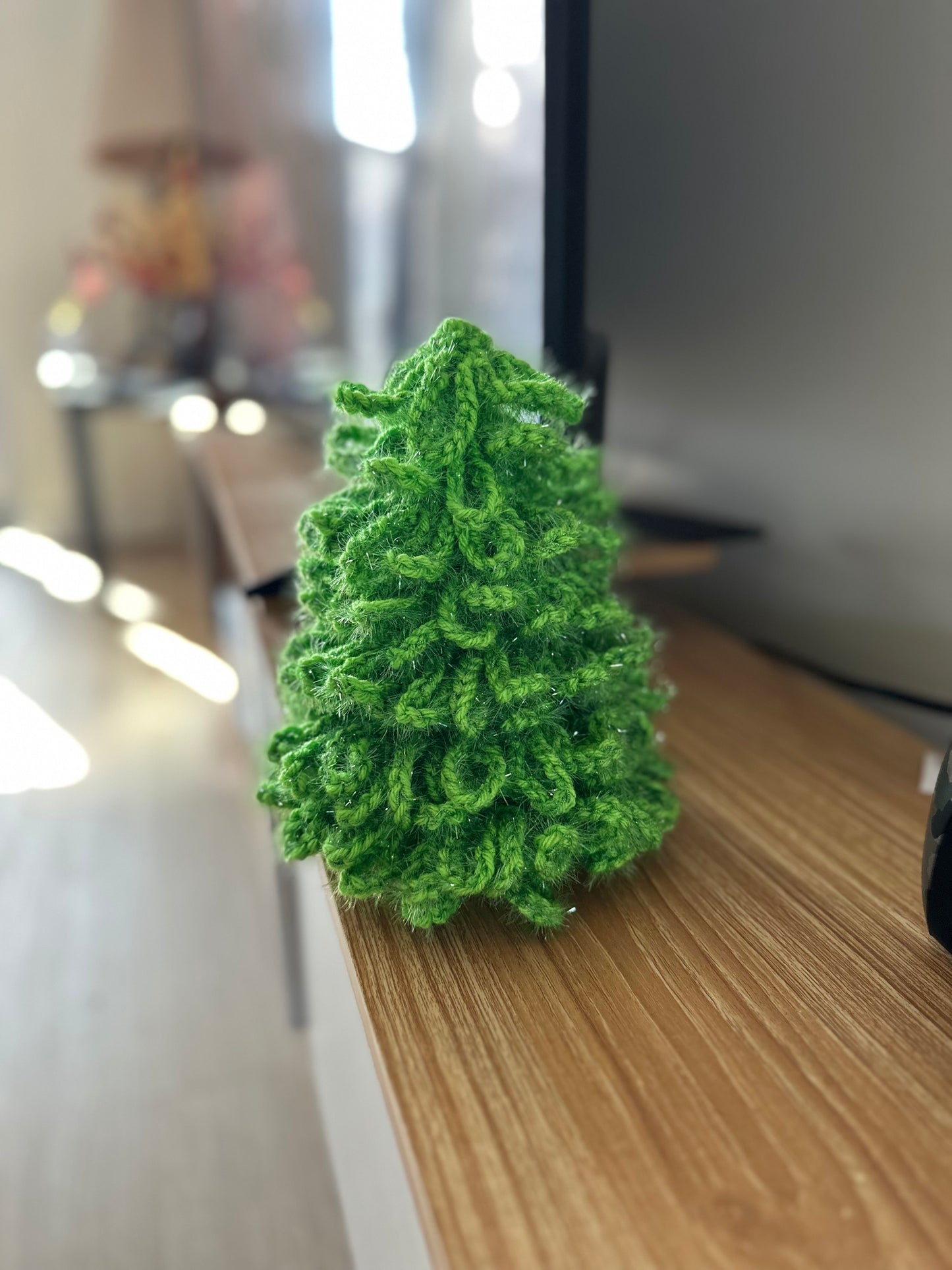 Crochet Christmas decor tree crafted from glossy green yarn with fluffy texture and shimmer