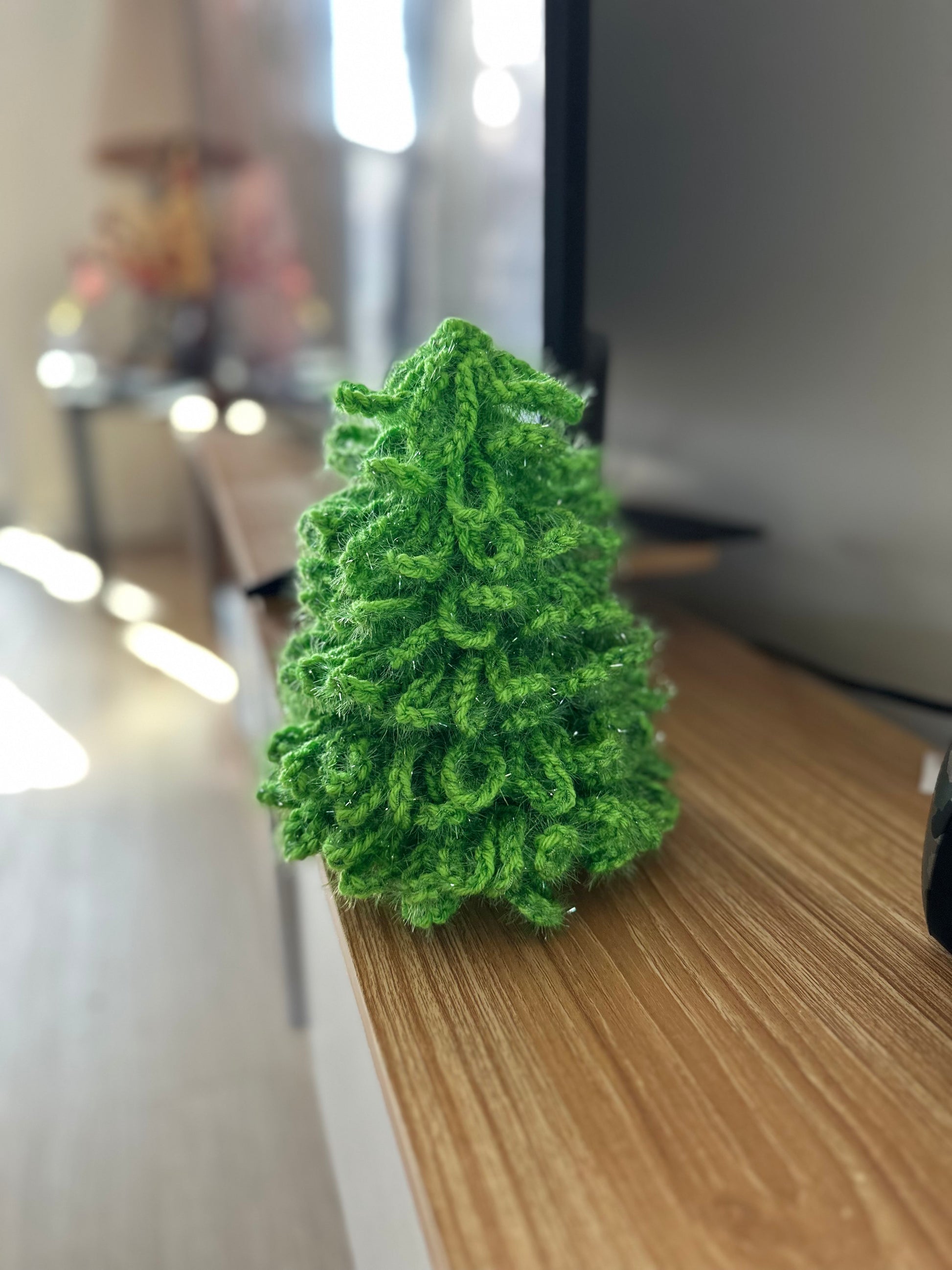 Crochet Christmas decor tree crafted from glossy green yarn with fluffy texture and shimmer