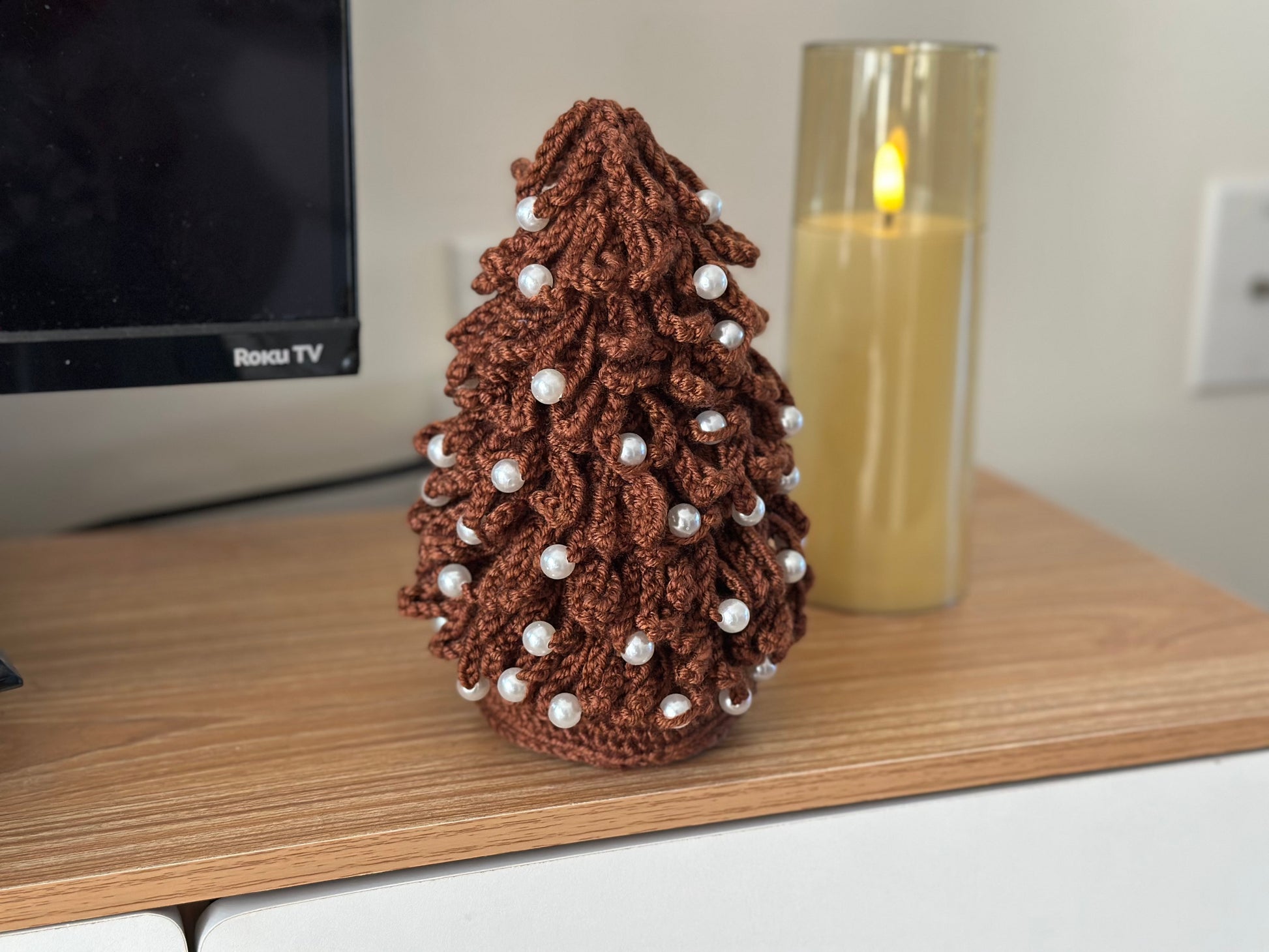 Close-up of brown crochet Christmas tree decorated with pearl beads