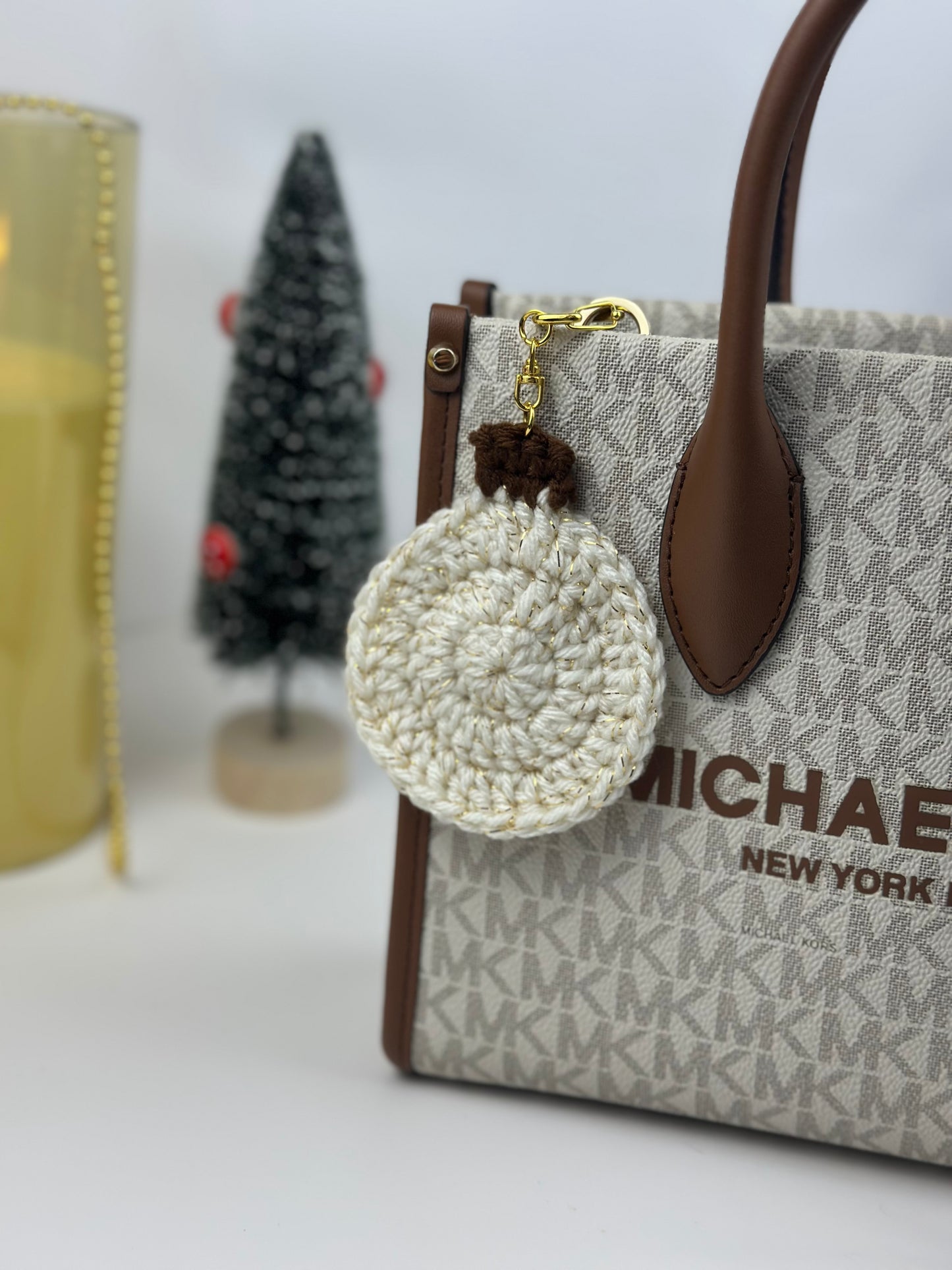 White sparkly crochet Christmas ball keychain with metal clasp, handmade from acrylic yarn.