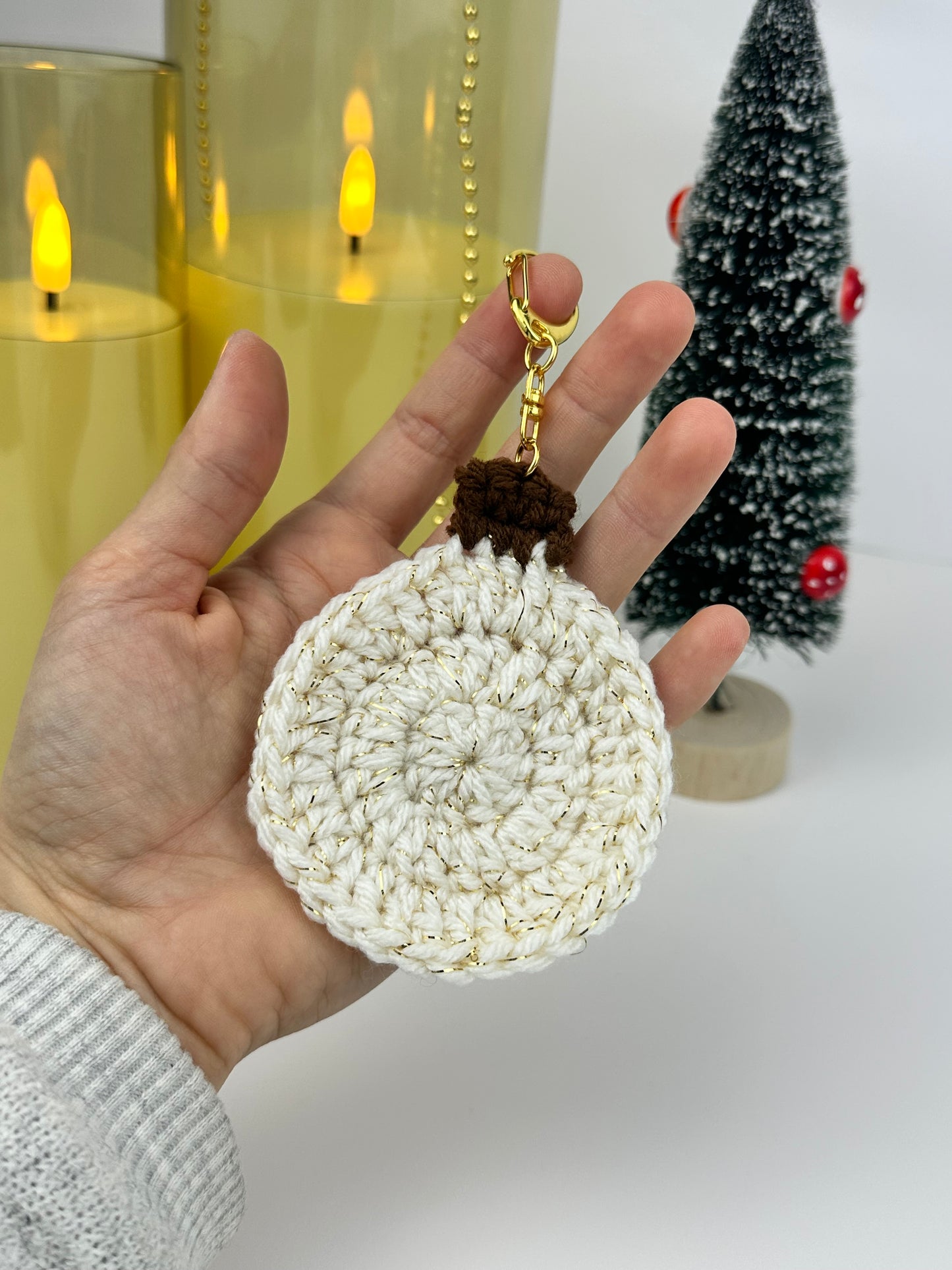 Handmade white crochet holiday ornament keychain with subtle glitter yarn.