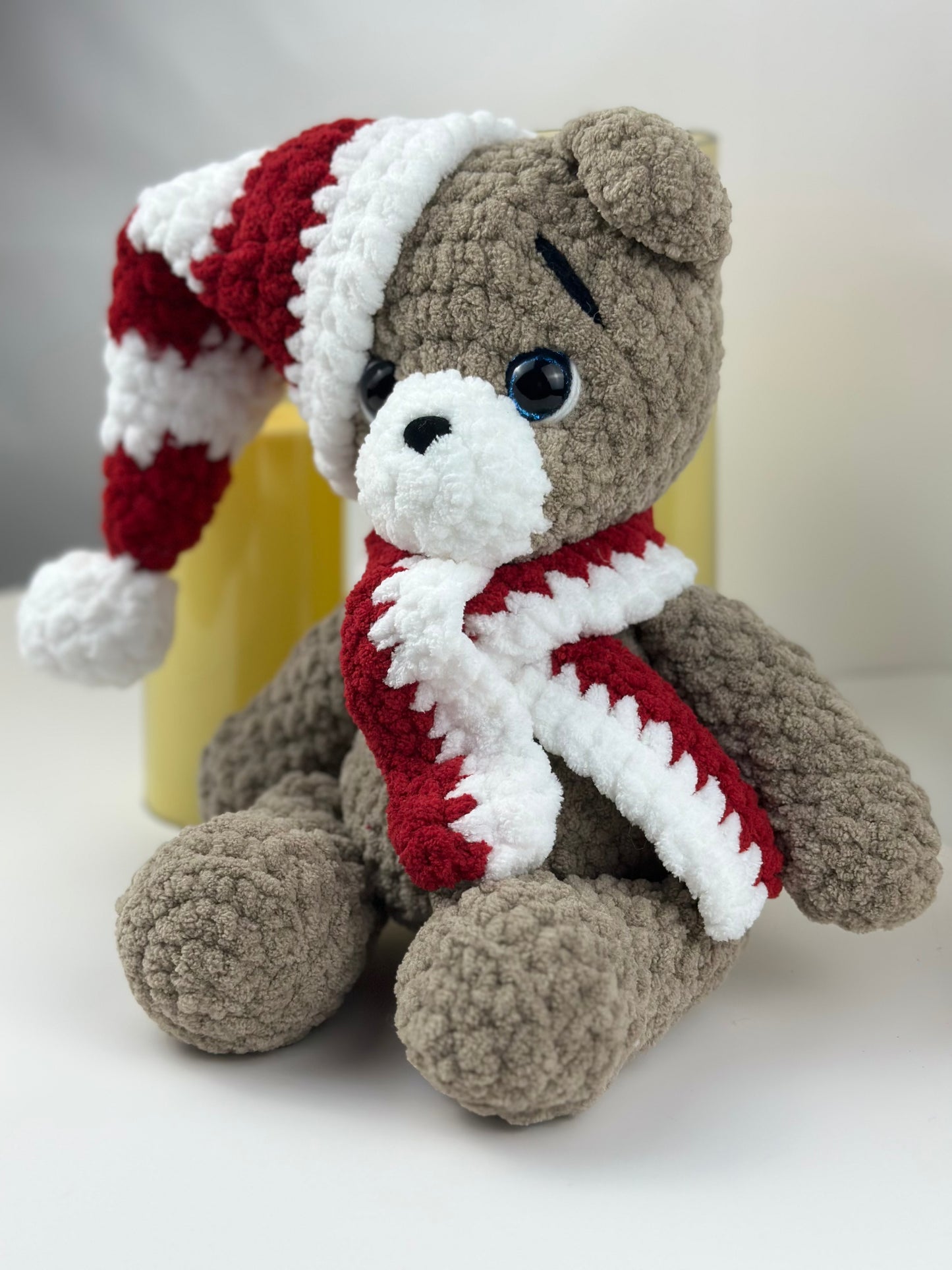 Hand-crocheted Christmas teddy bear toy made from plush yarn, featuring a cozy handmade design.
