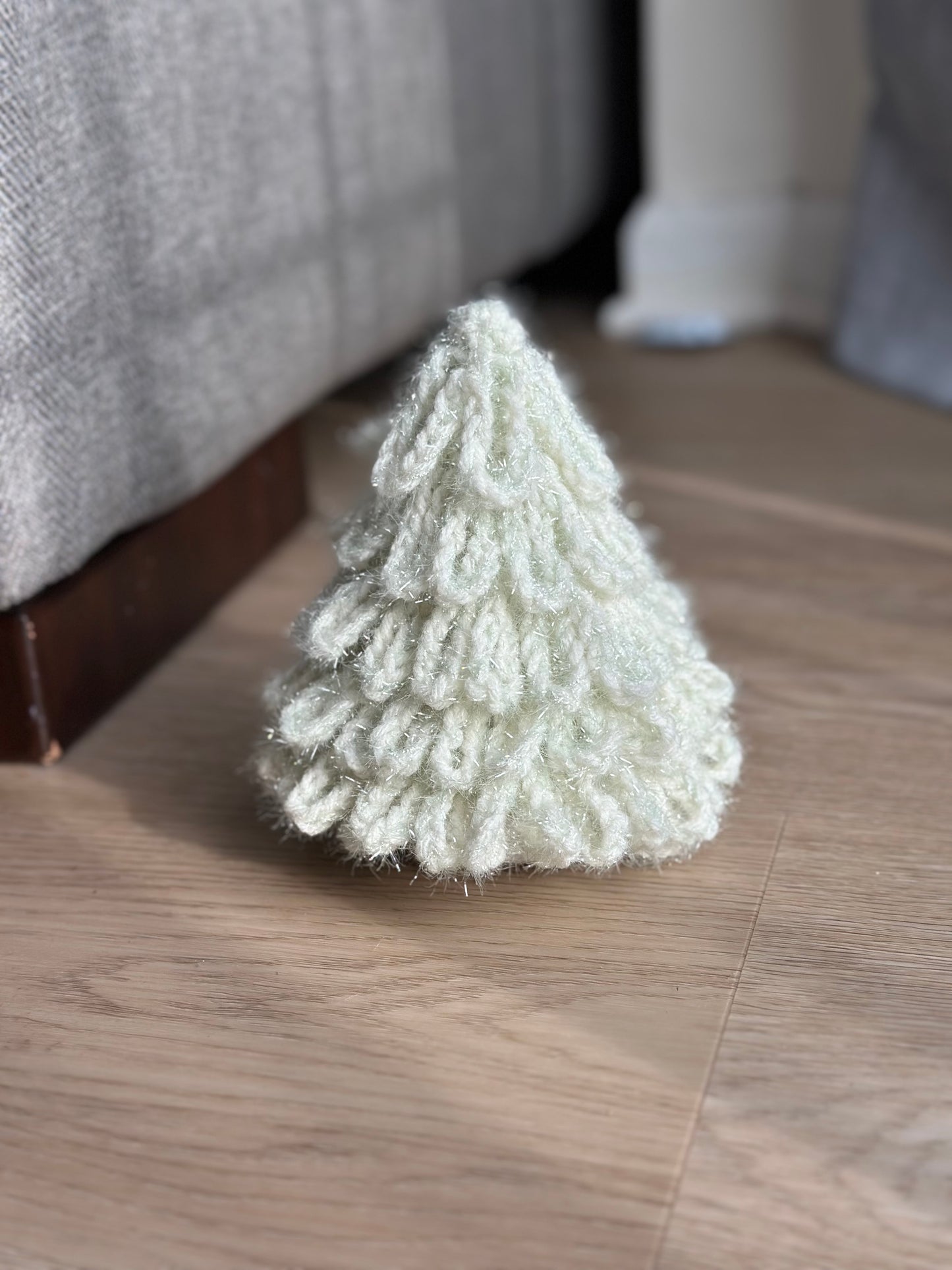 Crochet Christmas tree ornament in soft white, cozy winter decoration.