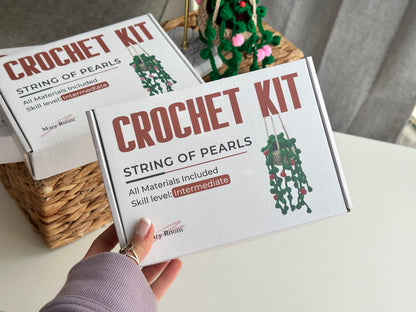 Crochet DIY kit packaging with 'String of Pearls' design on a white surface.