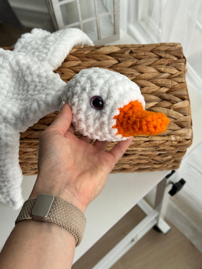 Crochet comfort goose plush toy held in hands for size reference