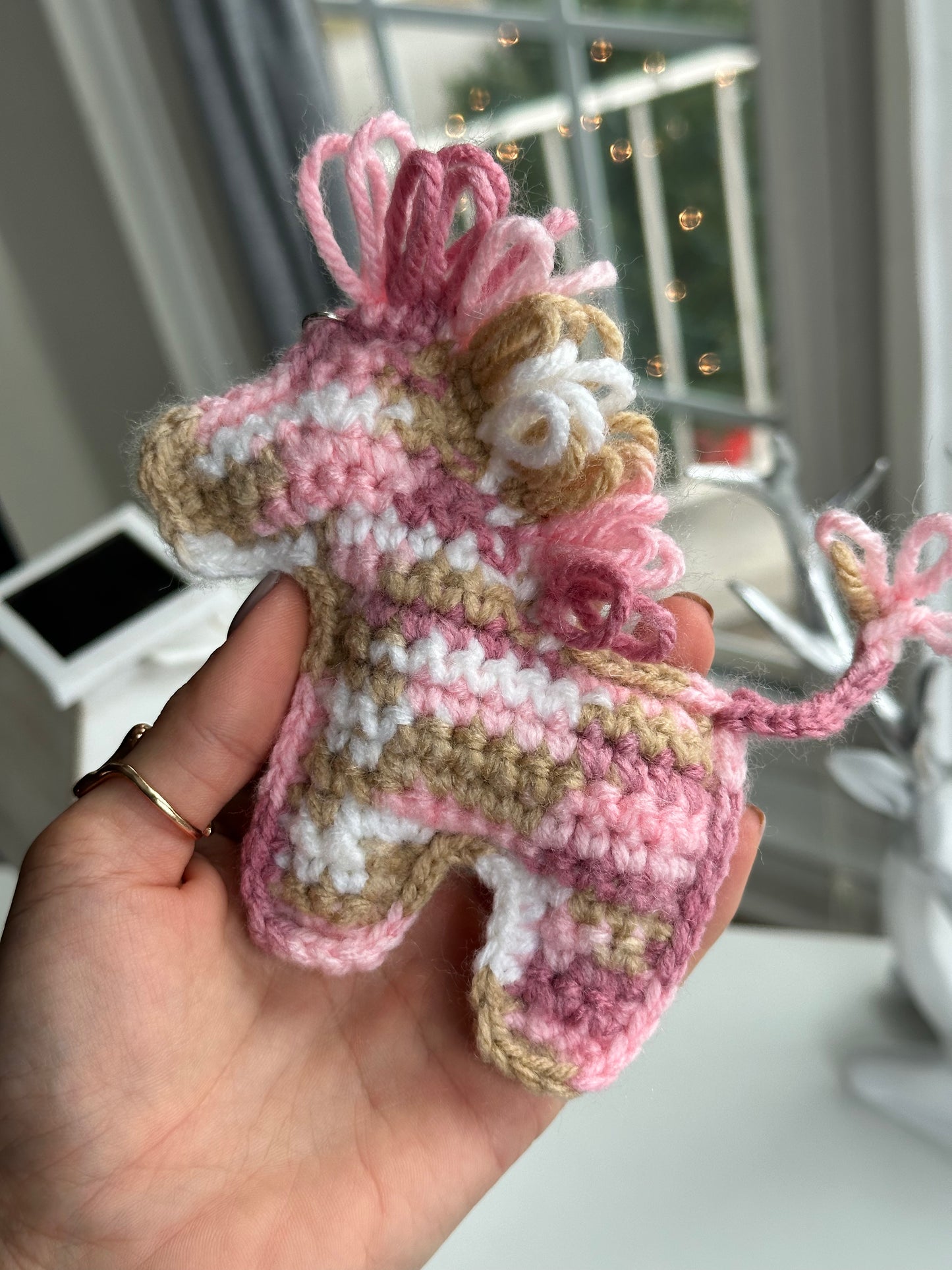 Colorful crochet horse charm hanging on a key ring, handmade mini pony keychain gift