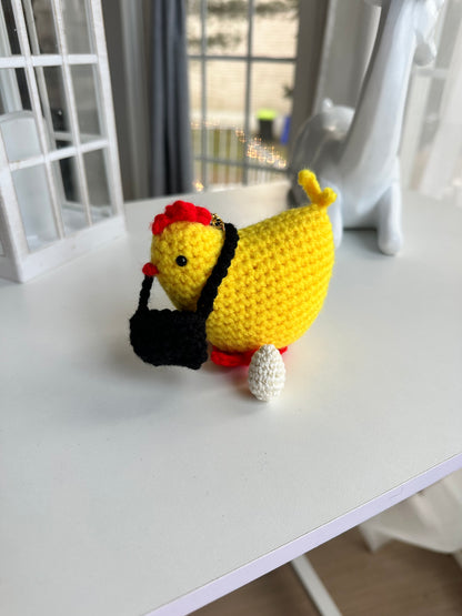 Handmade crochet chicken keychain with egg with golden clasp on white background