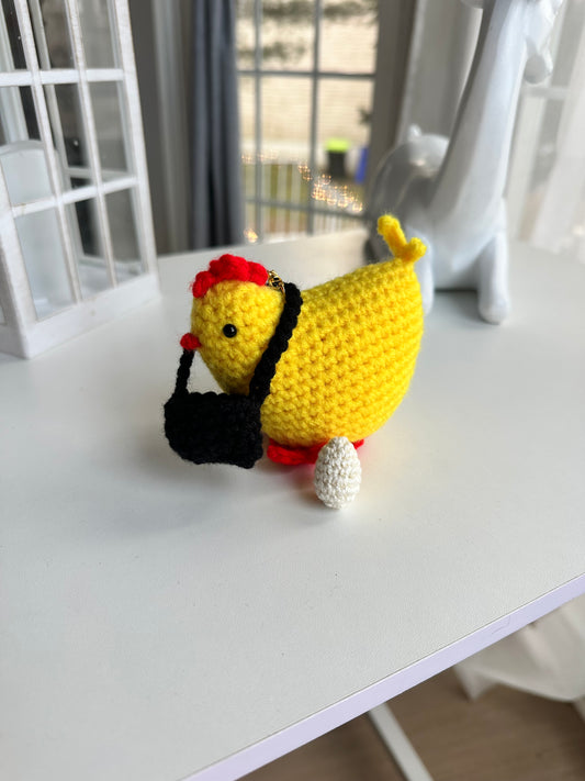 Handmade crochet chicken keychain with egg with golden clasp on white background