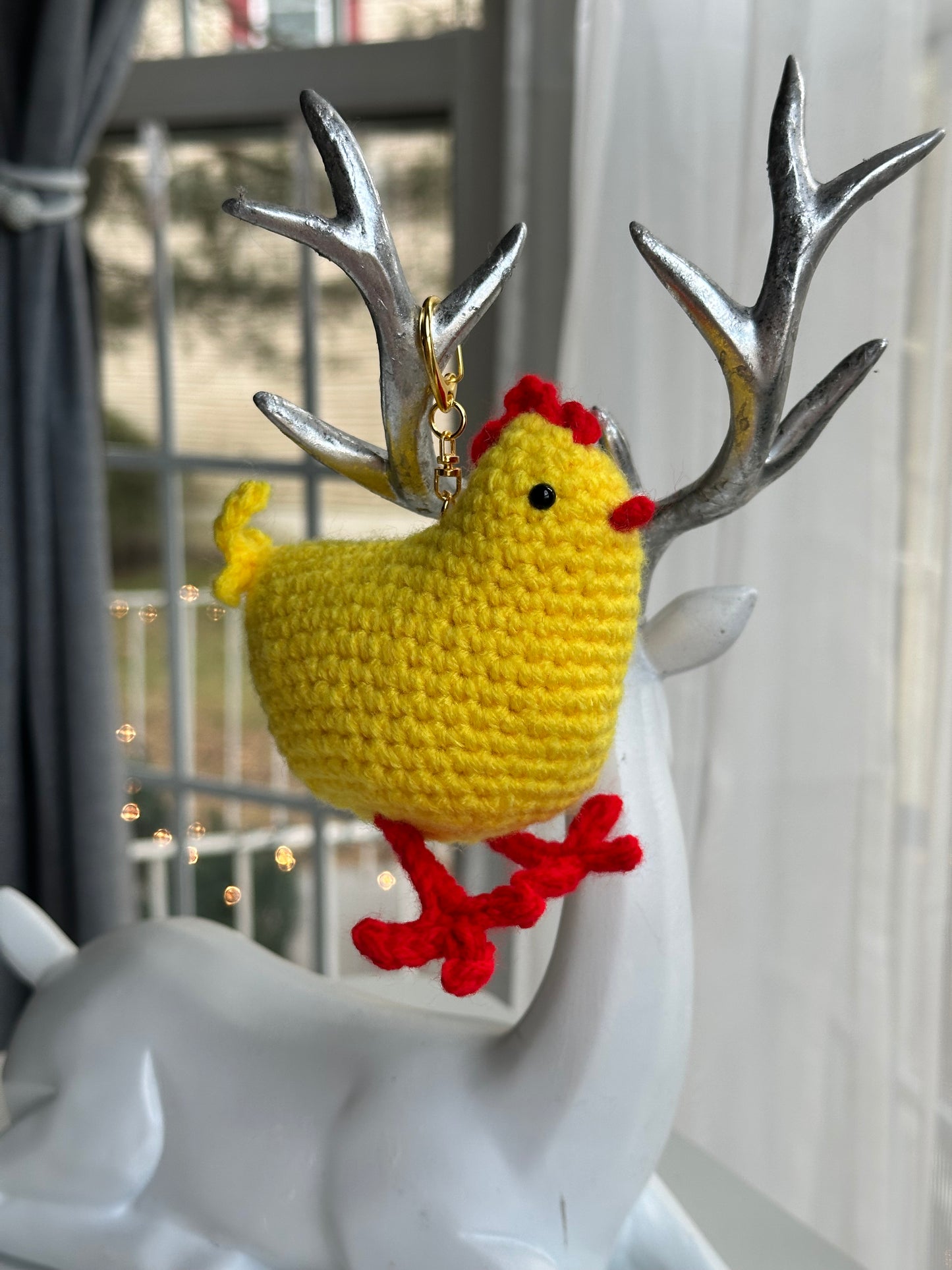 Chicken-shaped keychain accessory hanging from a backpack