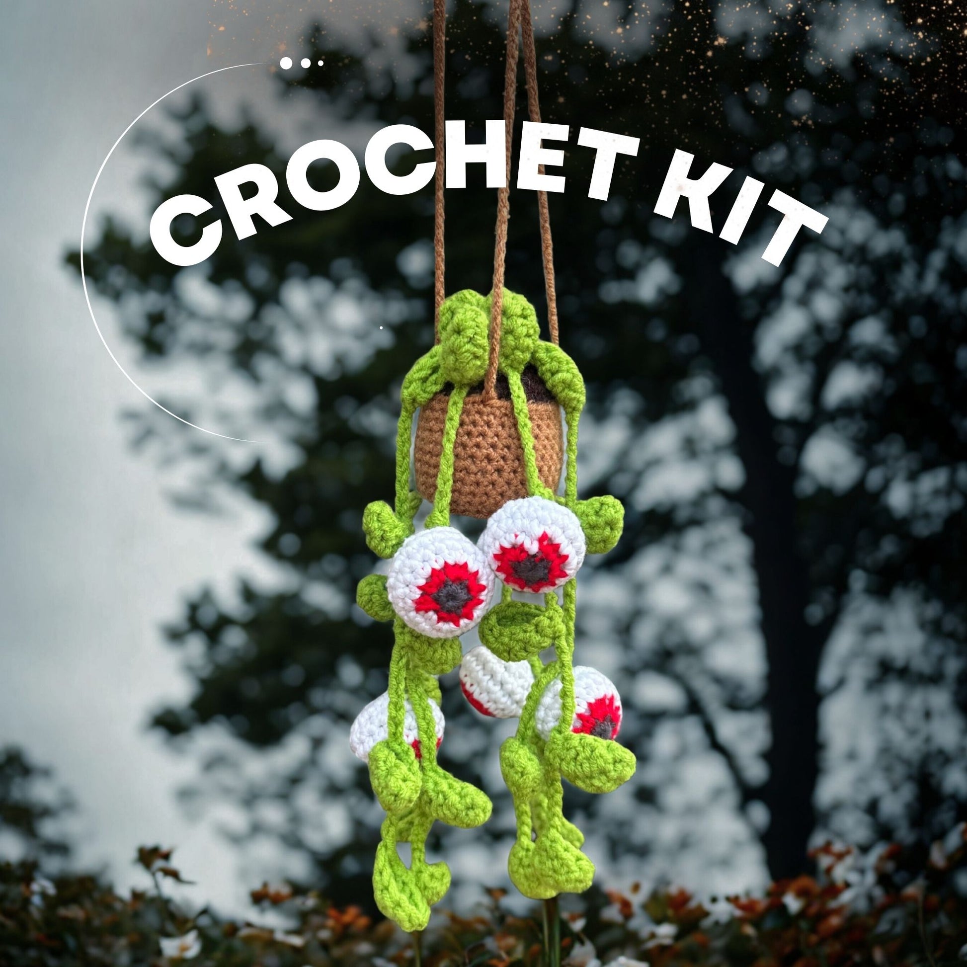Spooky Eyes crochet plant kit hanging outdoors with dramatic cloudy background – handmade Halloween-themed yarn decor