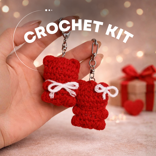 Close-up of red crochet teddy bear keychains held in hand, showing magnets and Valentine-style bows – DIY Crochet Kit for Valentine’s Day (Kissing Bears)