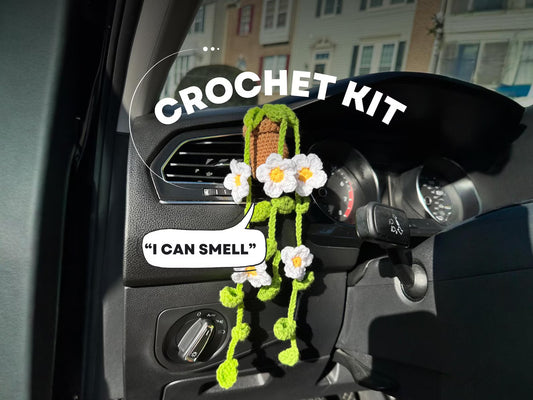 Crochet daisy vent clip hanging in a car with “I can smell” quote – front view. crochet diy kit with flowers