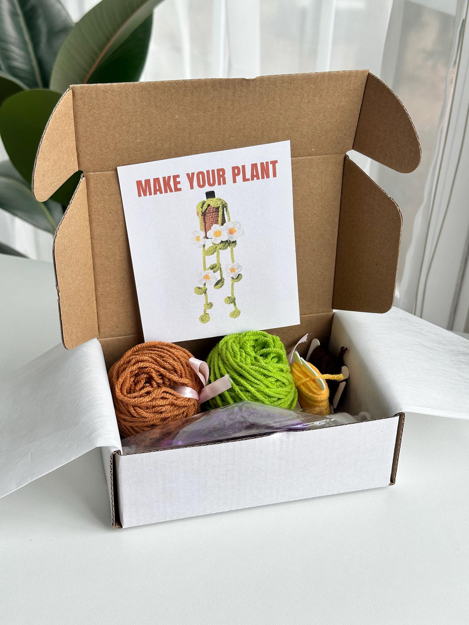 Open kit box with yarn, tools, and pattern card displayed neatly. crochet diy kit with flowers and sachet of lavender