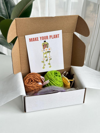 Open kit box with yarn, tools, and pattern card displayed neatly. crochet diy kit with flowers and sachet of lavender