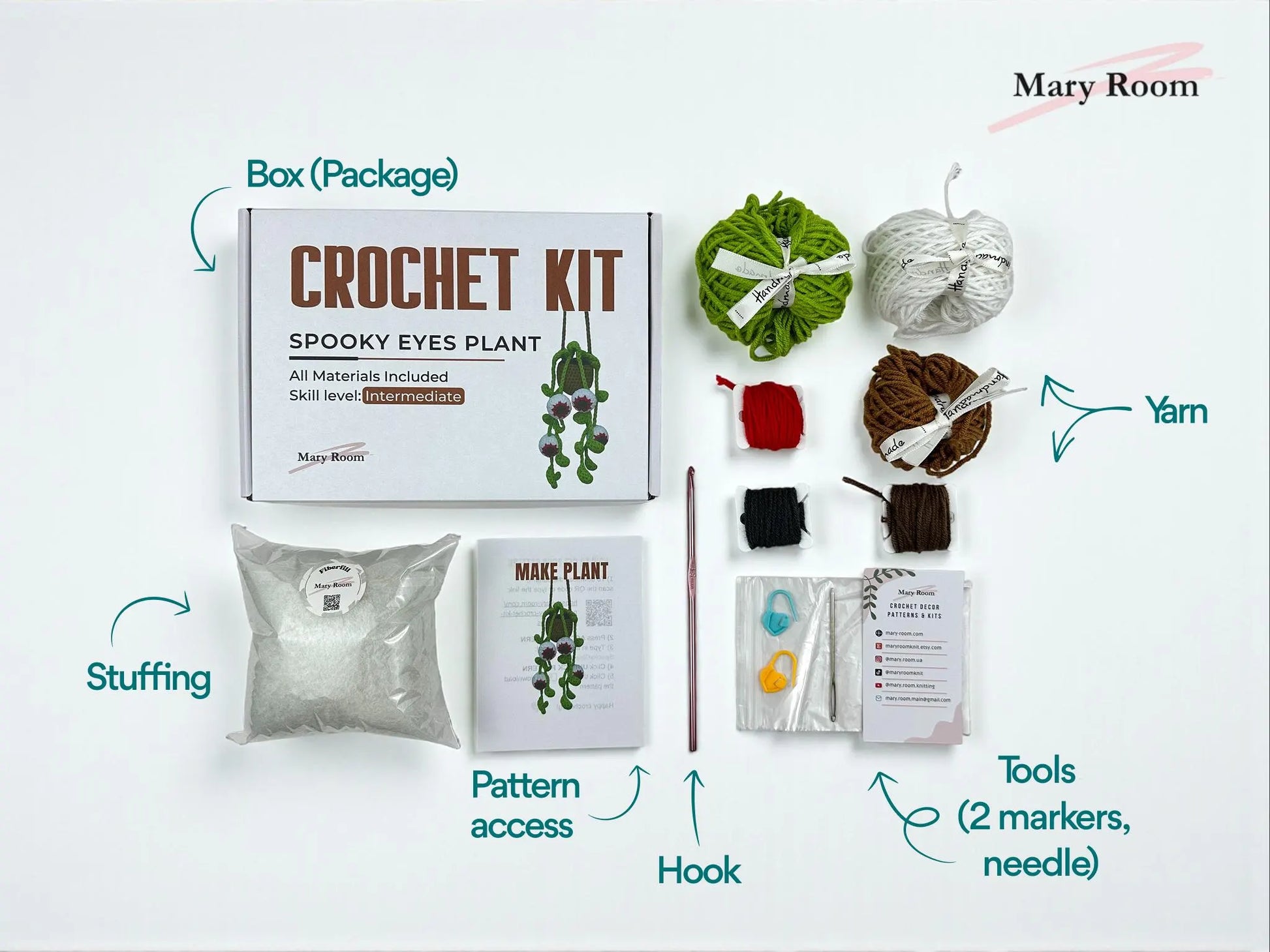 Flat lay of Spooky Eyes crochet kit packaging showing yarn, stuffing, hook, tools, and QR code pattern access.